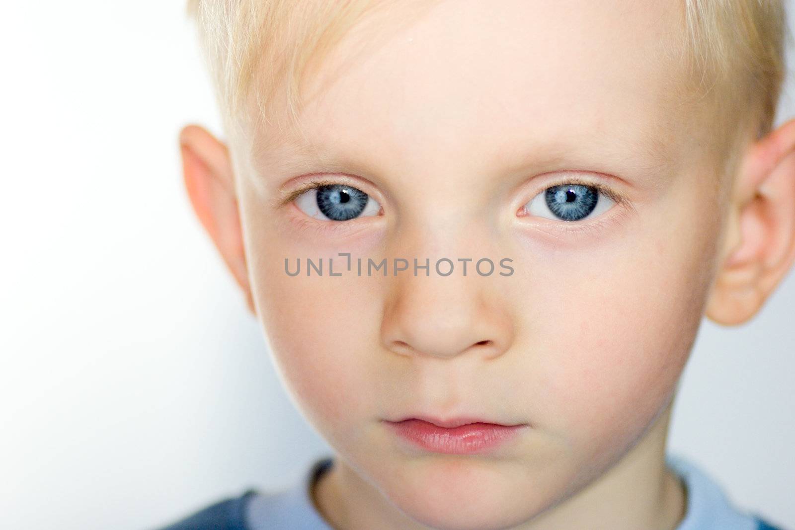Pensive Serious boy with blond hair Closeup 