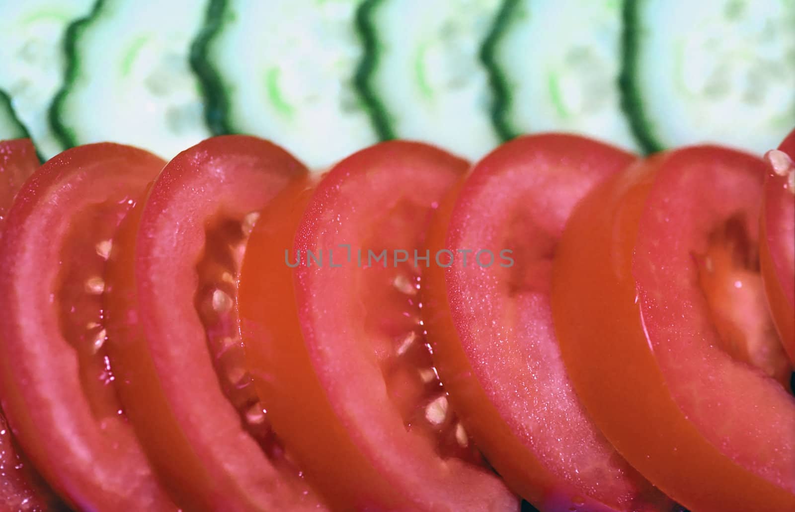 Tomatoes and cucumbers slices close up background 