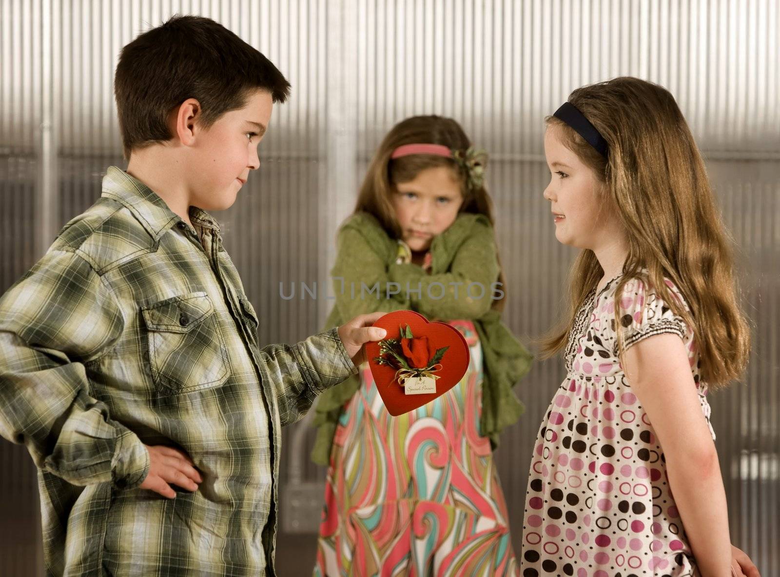 Little boy giving a candy heart to girl causes anger