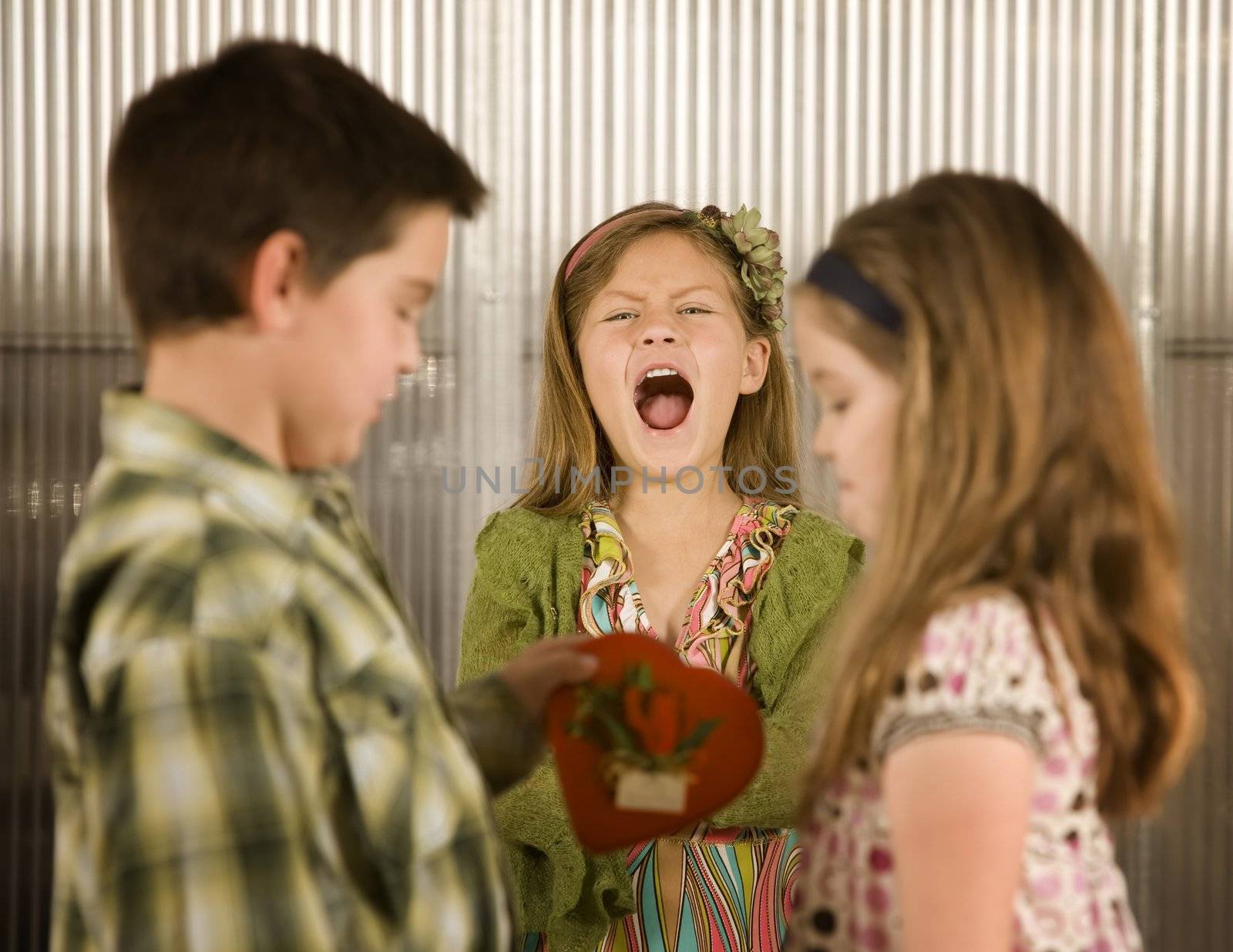 Little boy giving a candy heart to girl causes anger