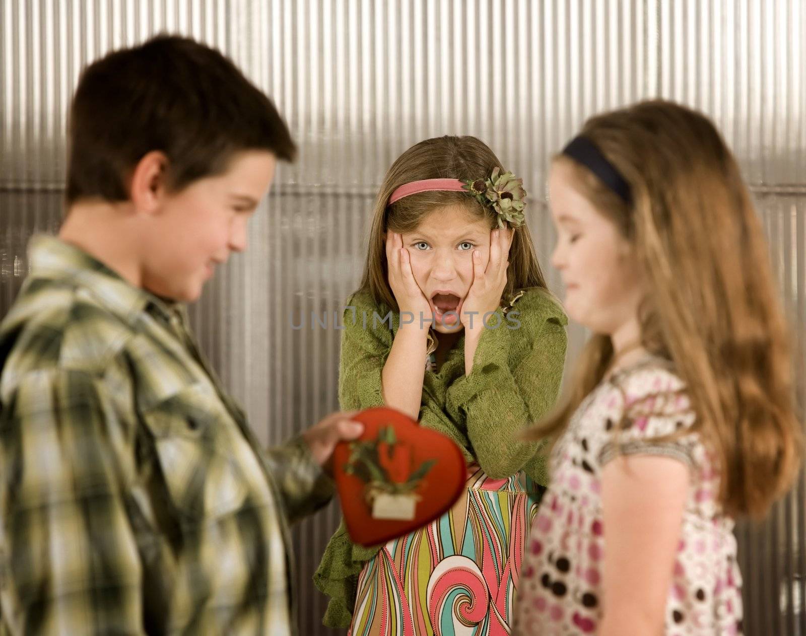 Little boy giving a candy heart to girl causes anger