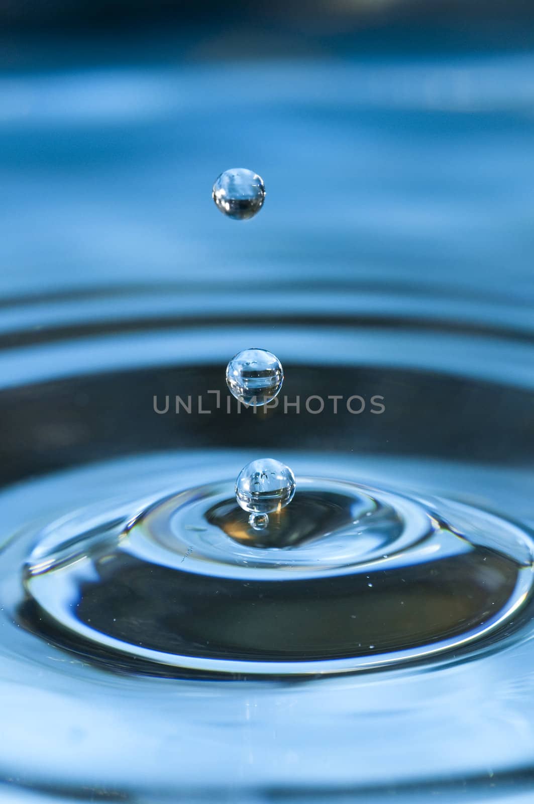 Bouncing water drops in blue background