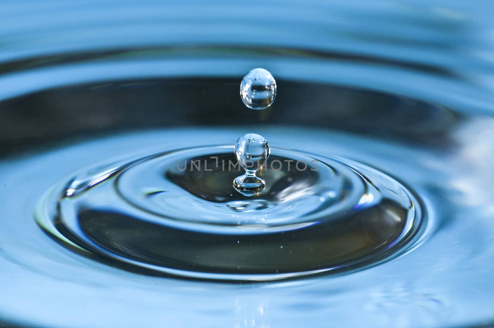 Bouncing water drops in blue background