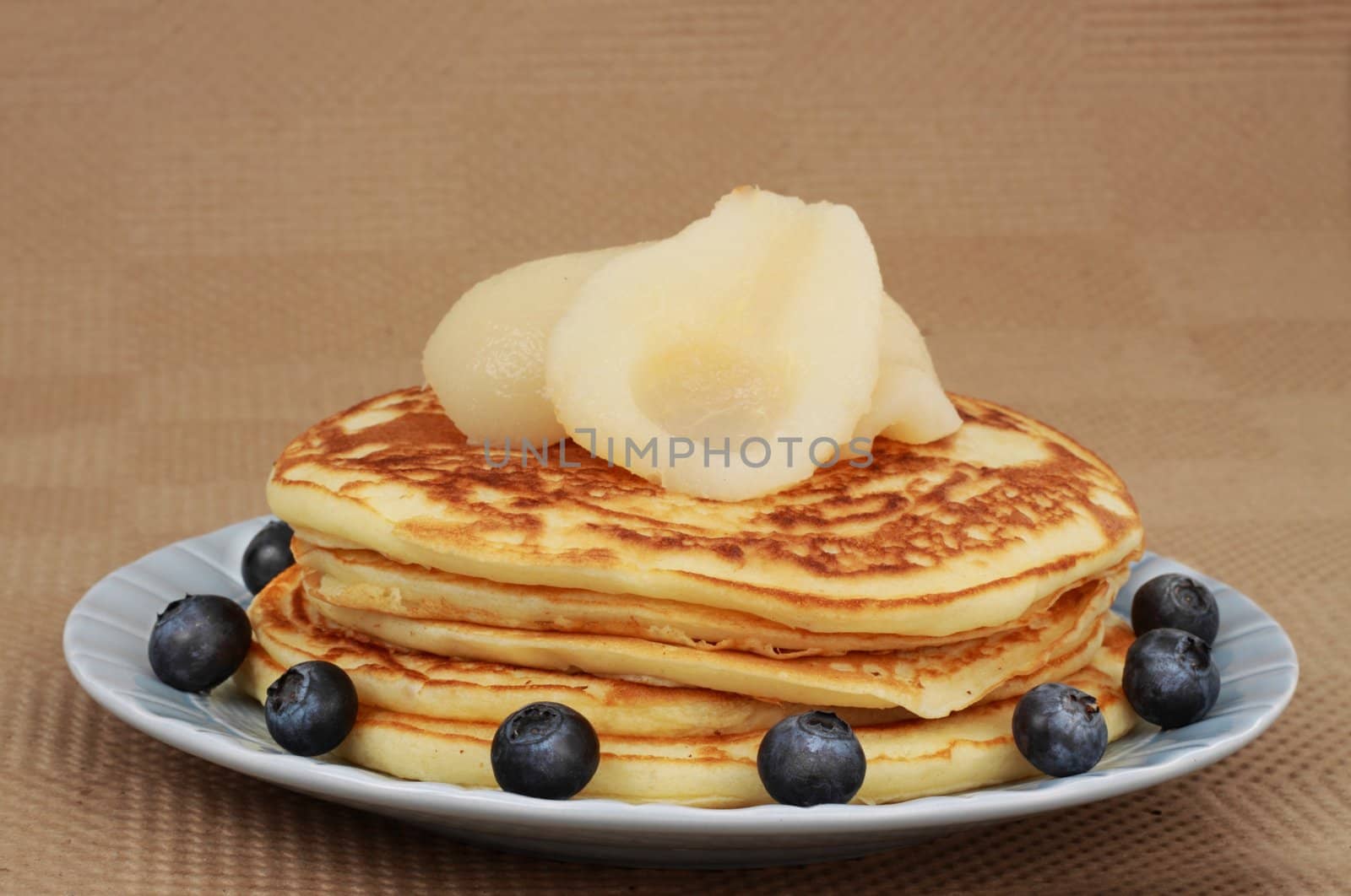 pancakes with pears and blueberries in a blue plate