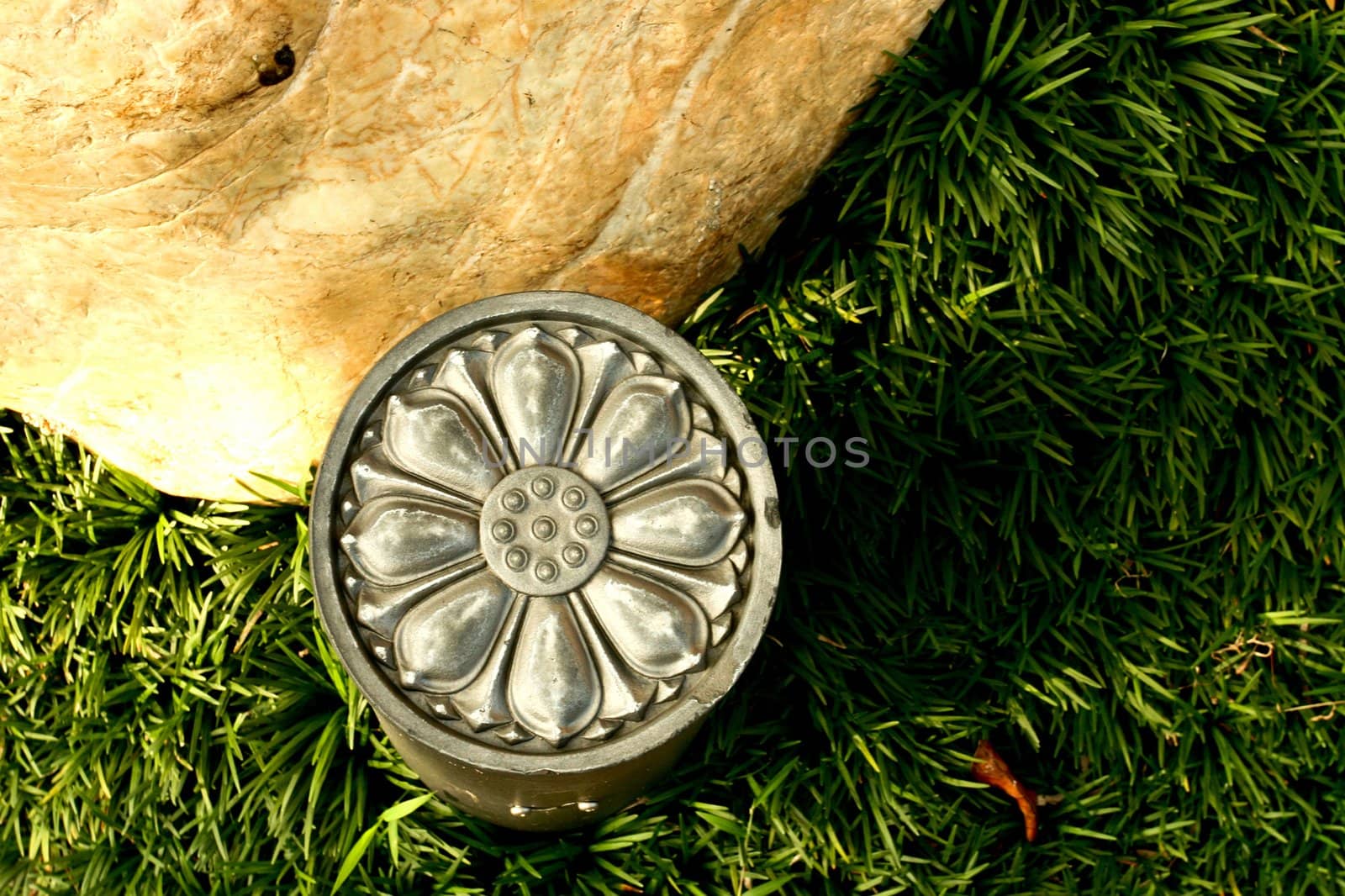 Metallic Floral Decoration with grass and stone in park under sunset