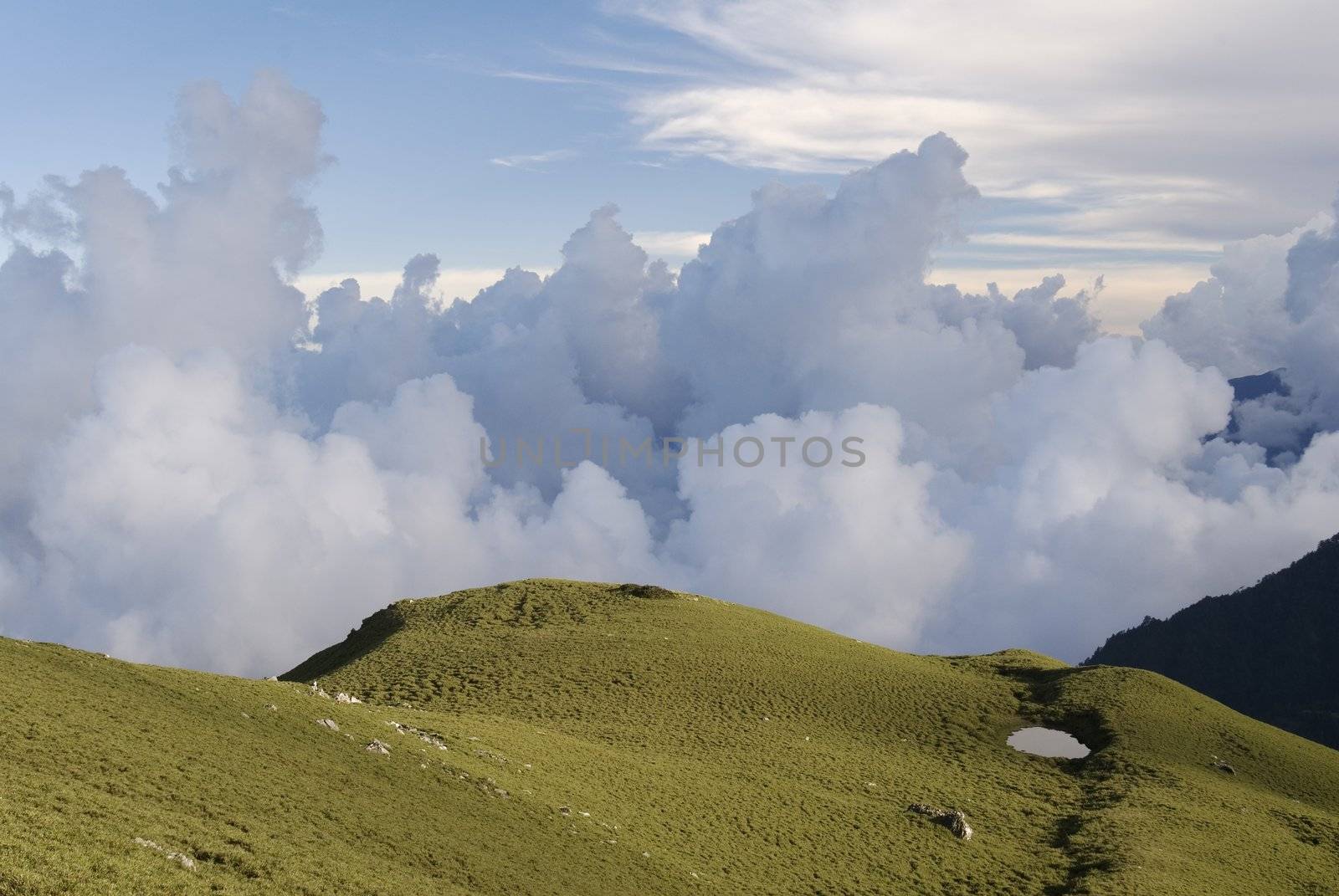 Beautiful lawn and clouds, the middle there is a lovely little lake.