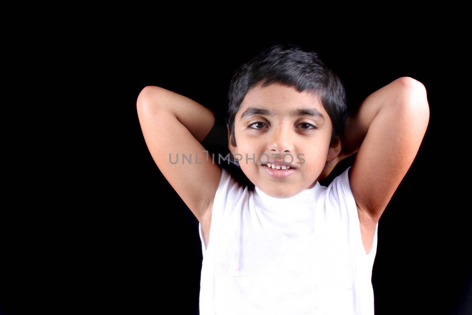 A portrait of a smart looking Indian kid, on black studio background.