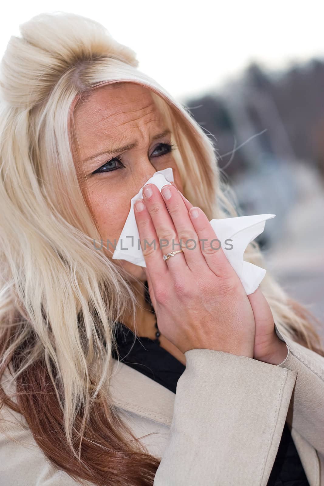 This young woman sneezing into a tissue either has a cold or really bad allergies.