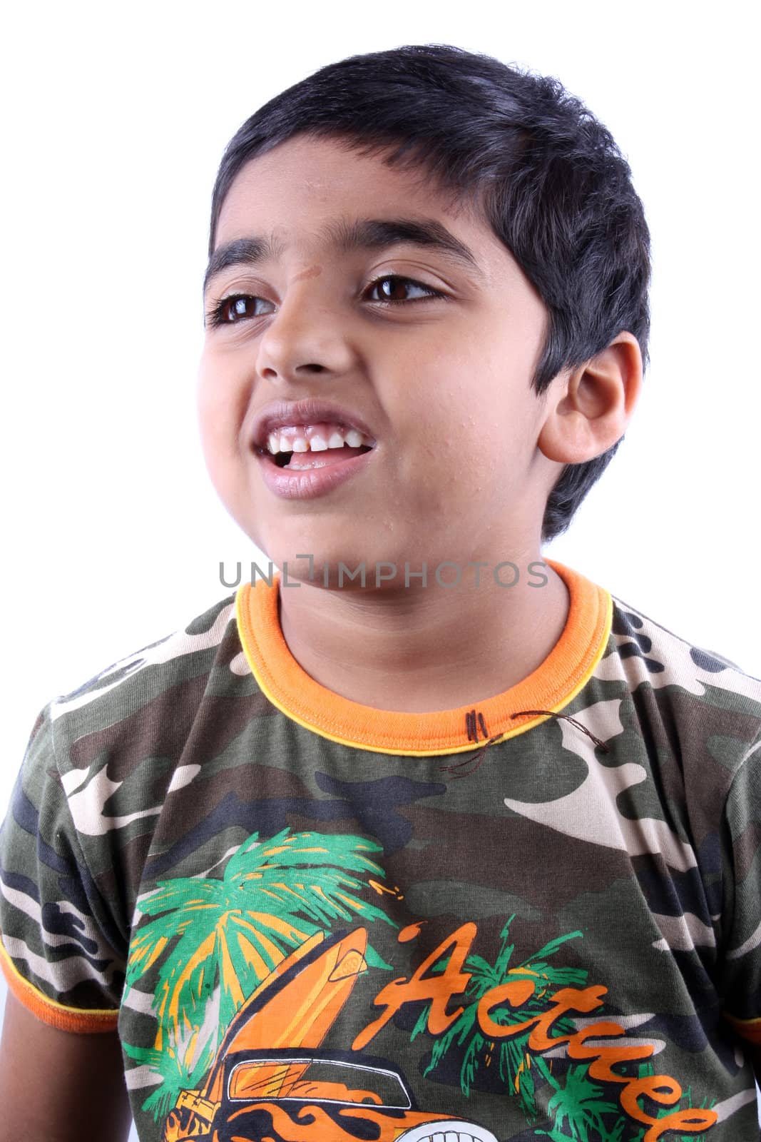 A portrait of a cute Indian kid laughing, on white studio background.