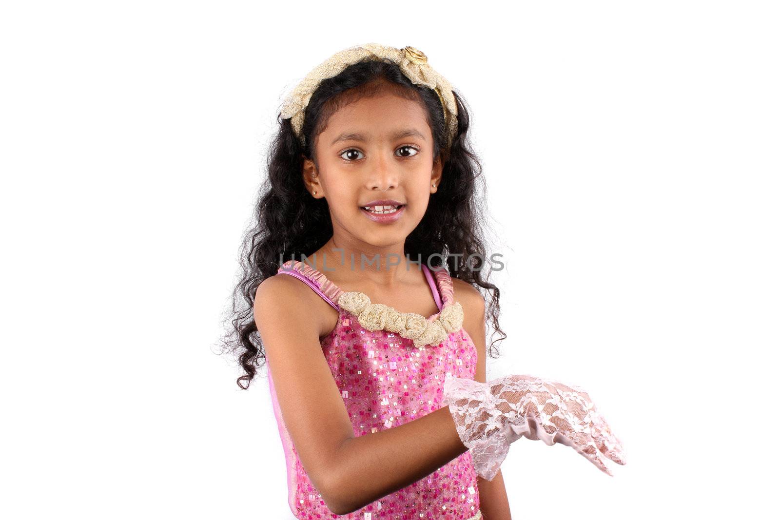 An Indian child actress wearing a pink frock and white gloves practicing her scene, on white studio background.