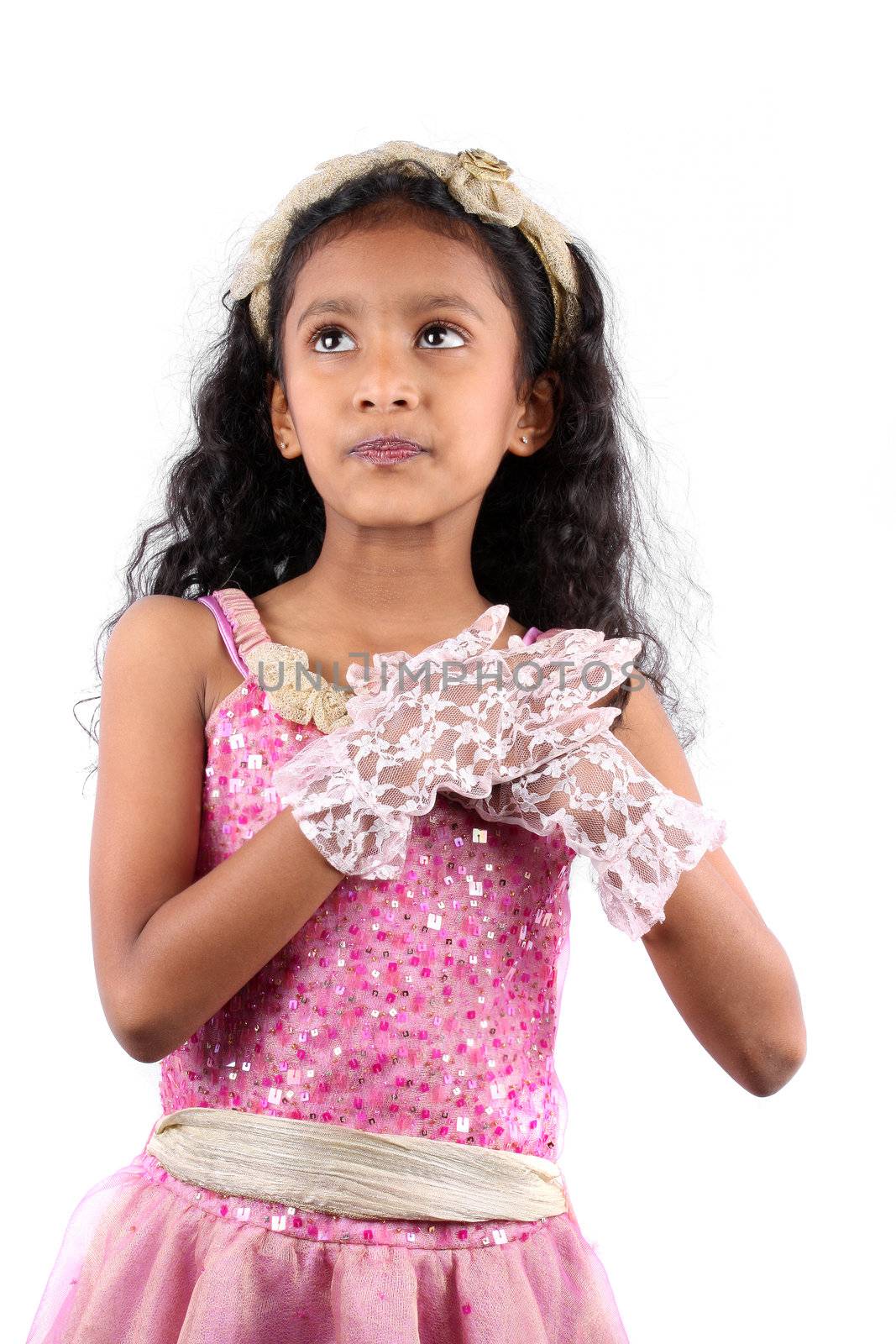 A cute daydreaming Indian girl making a wish, on white studio background.