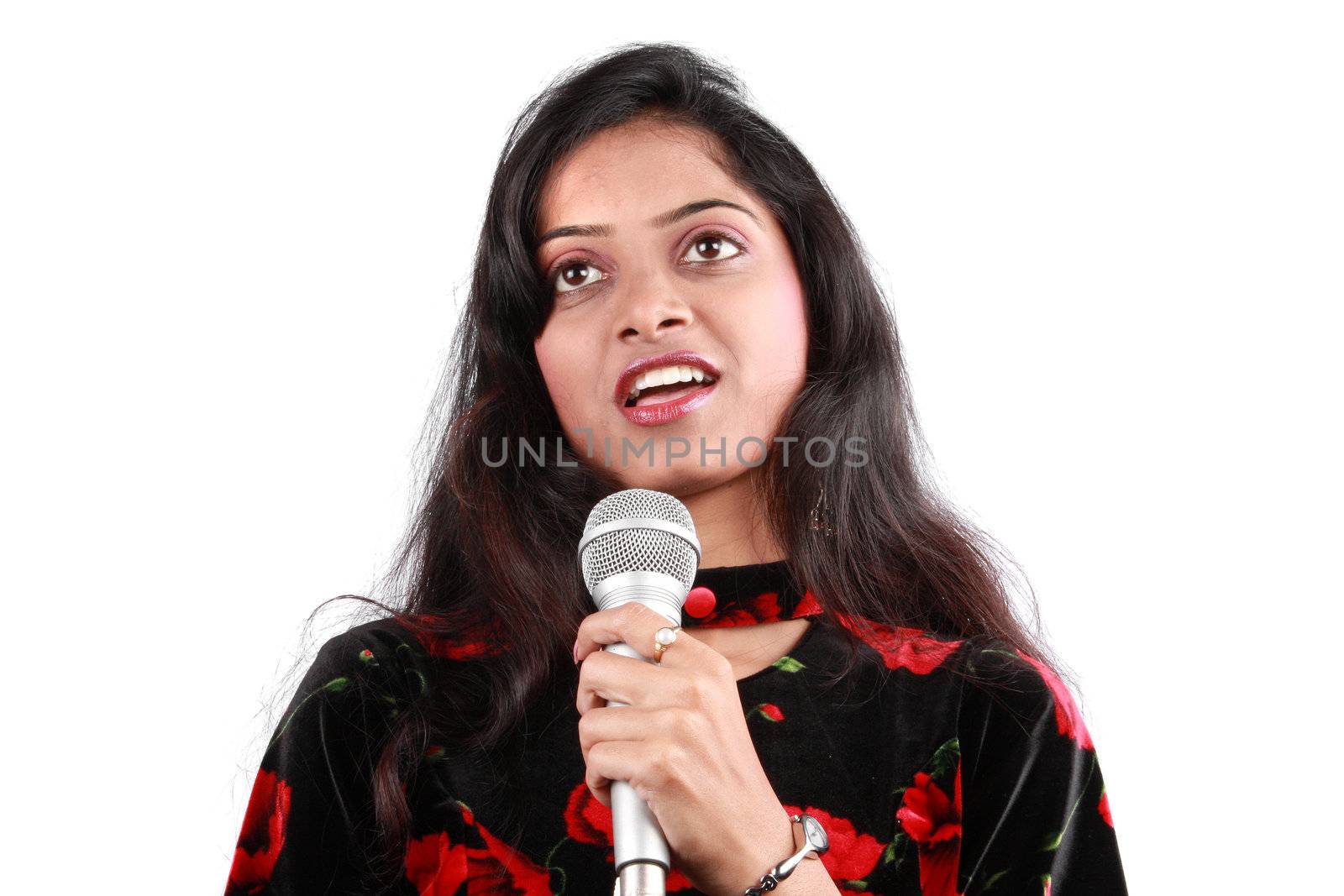 A portrait of a show host with a mic talking to the audience, on white studio background.