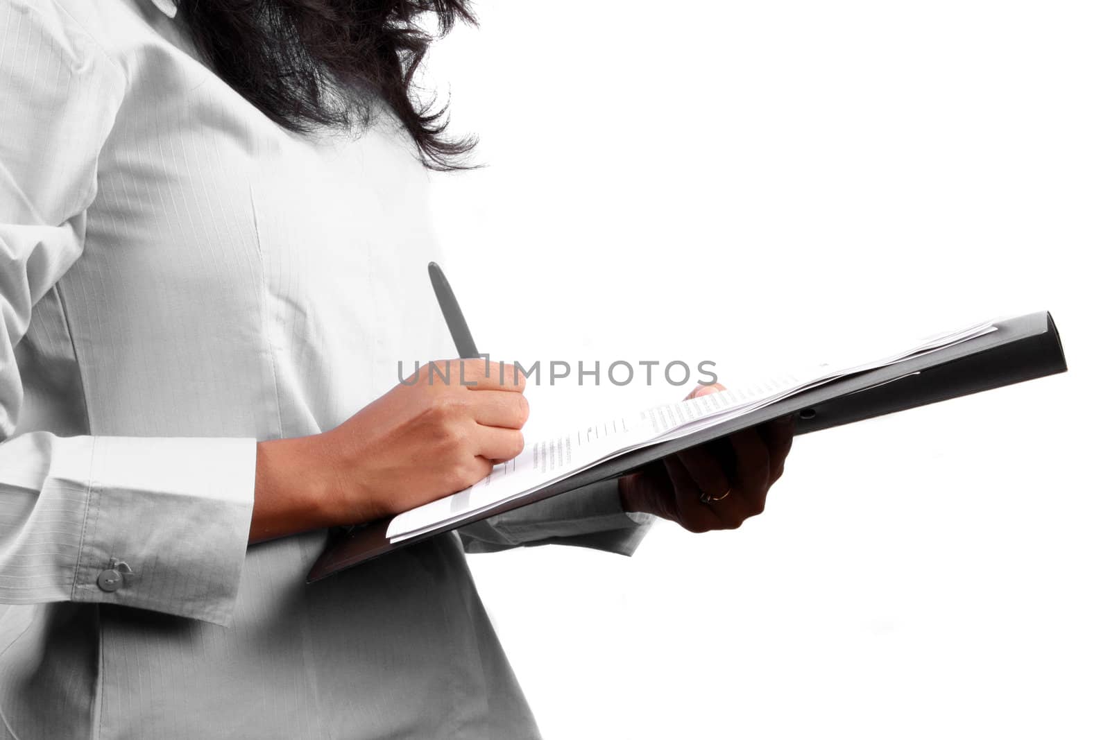 A metaphorical image with a view of the hand of a businesswoman signing a business contract / model release, on white studio background.