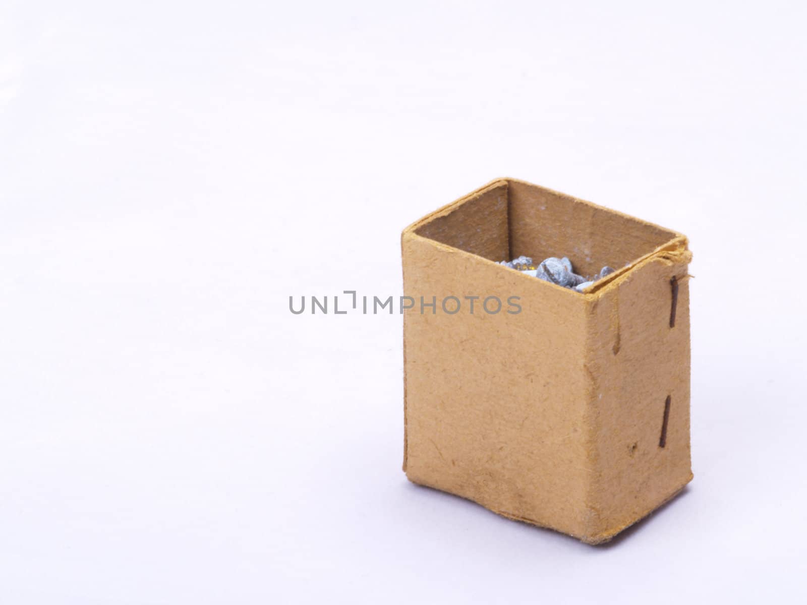 old grungy cardboard box with brass screws on off-white with copyspace