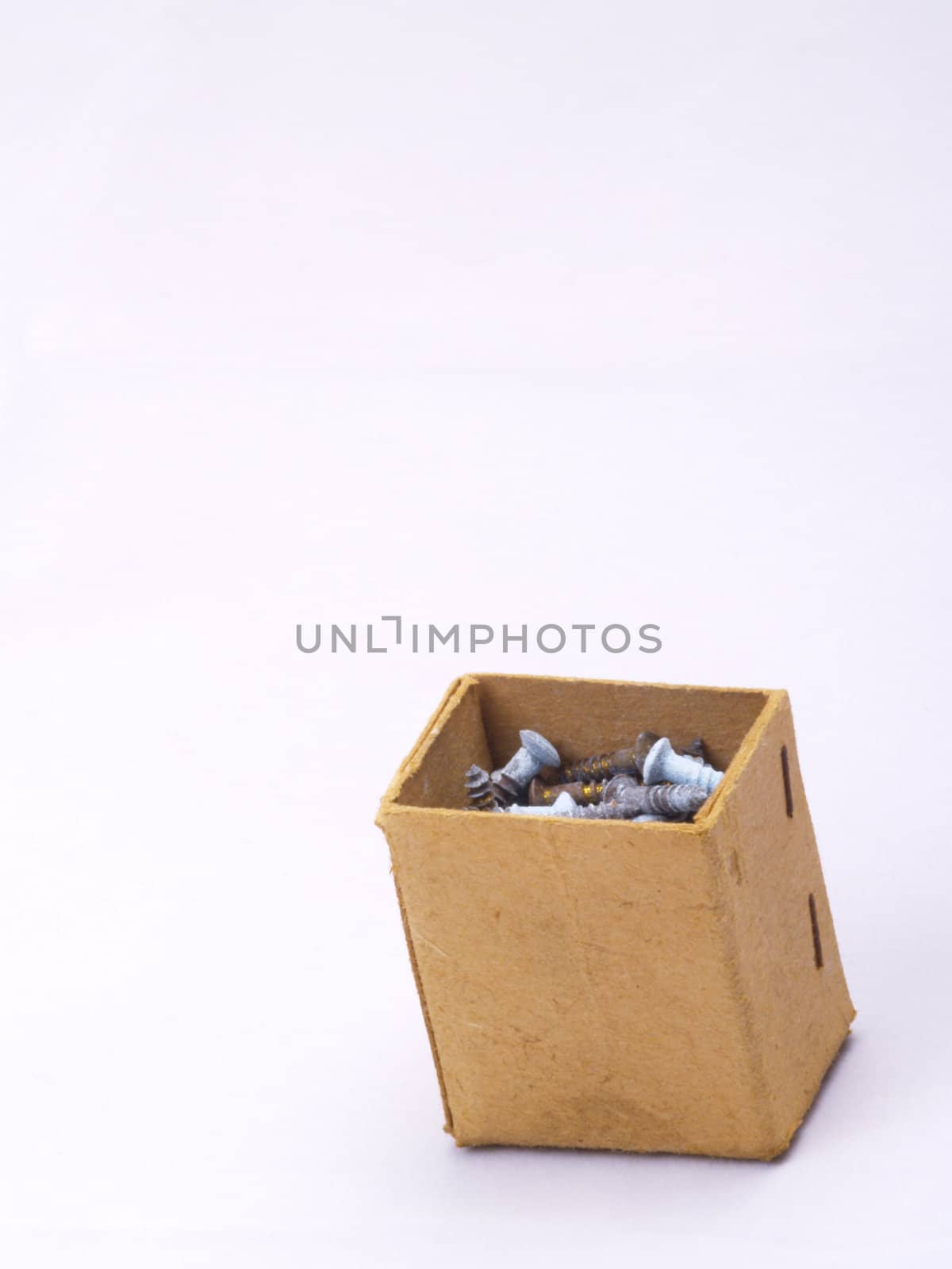 old grungy cardboard box with brass screws on off-white