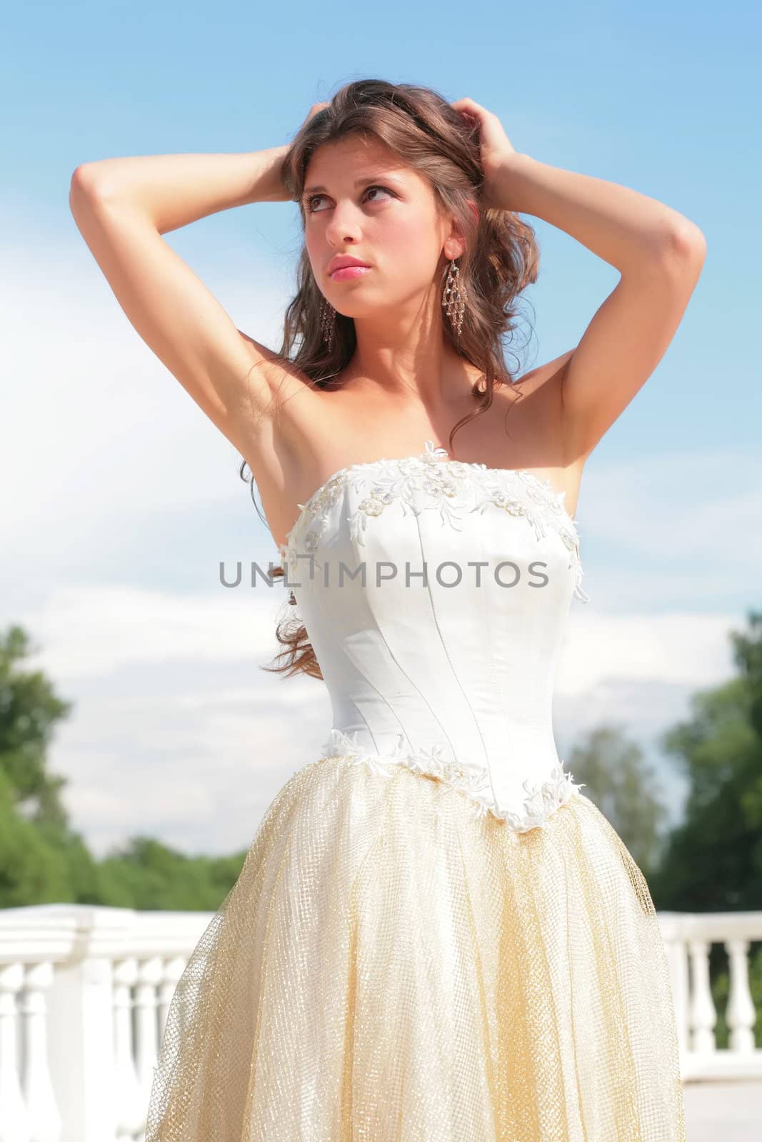 beautiful girl in wedding gown on background blue sky