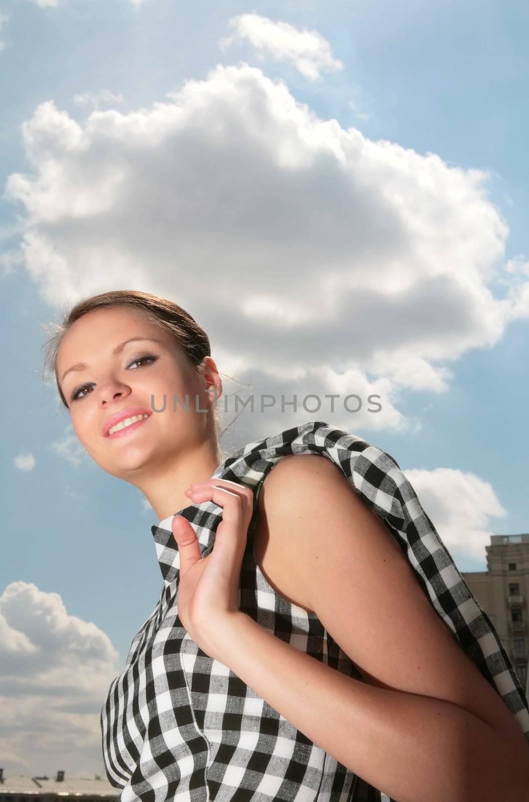 beautiful girl in plaid cloth on background blue sky with clouds