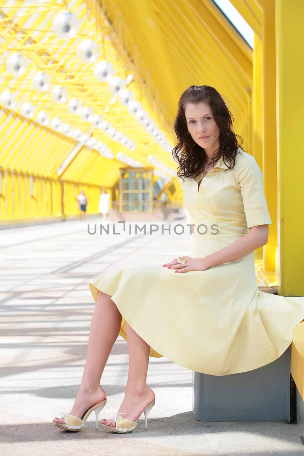 beautiful young woman in yellow dress in bright-yellow interiors