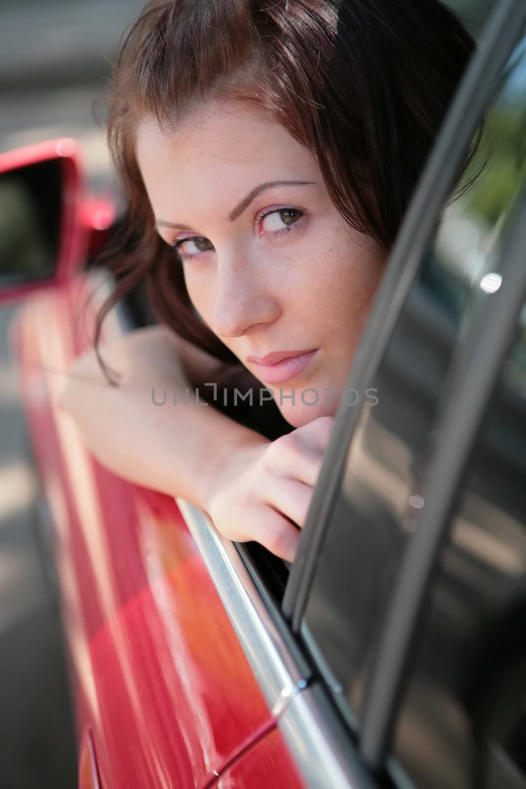close-up portrait of the beautiful girl in red car