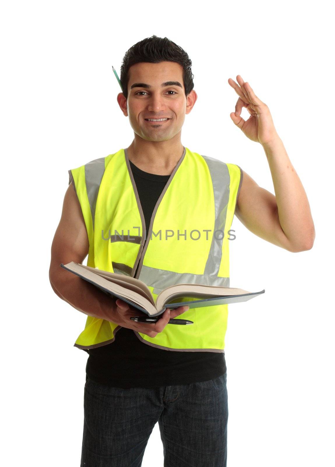 A student apprentice construction worker builder tradesman holding an open book and showing okay sign