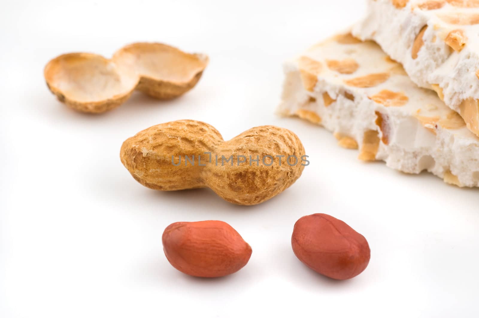 Nougat and peanuts on white background, close up shot.