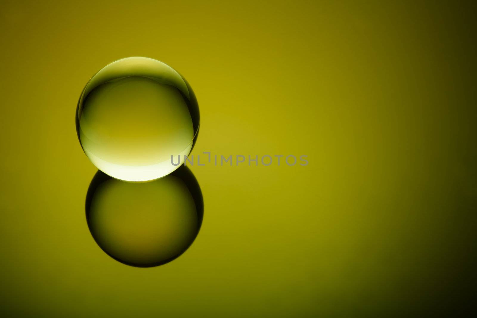 Crystal clear glass ball on an olive green geadient