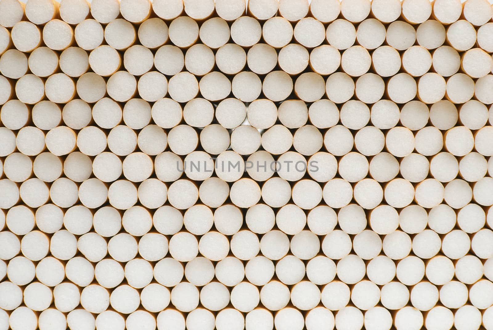 Symmetrical pile of cigarettes shot from the filter side.