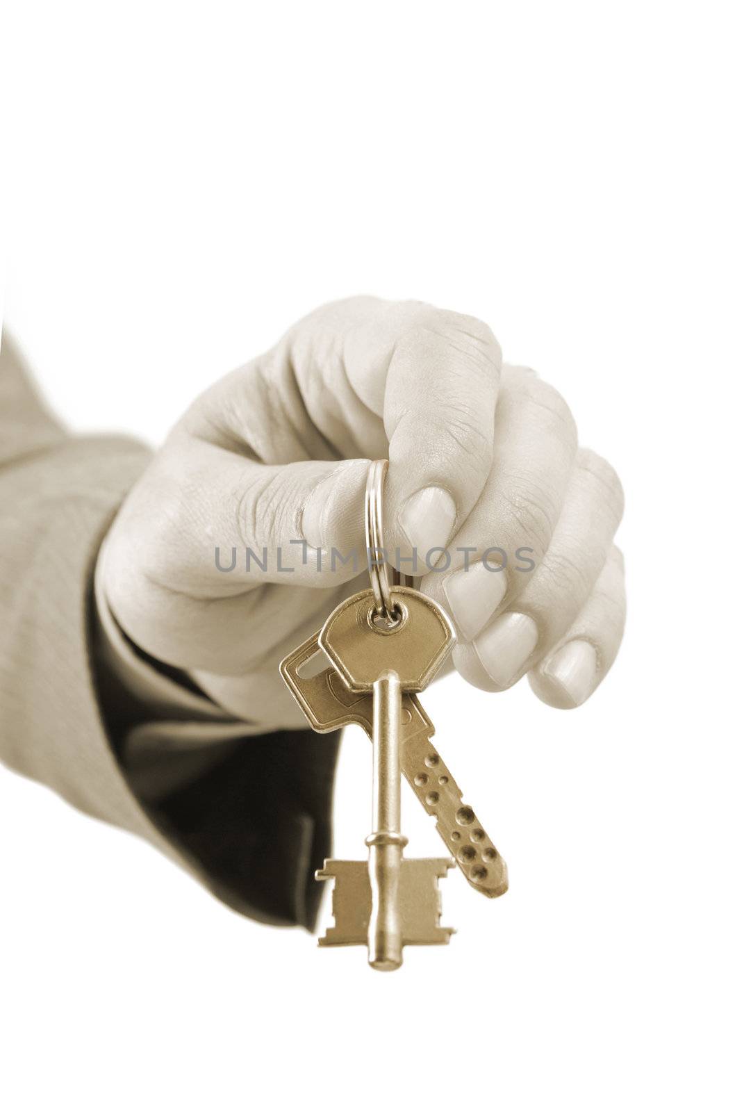 Close-up of a male real estate executive's hand holding two keys. Warm tones picture.
