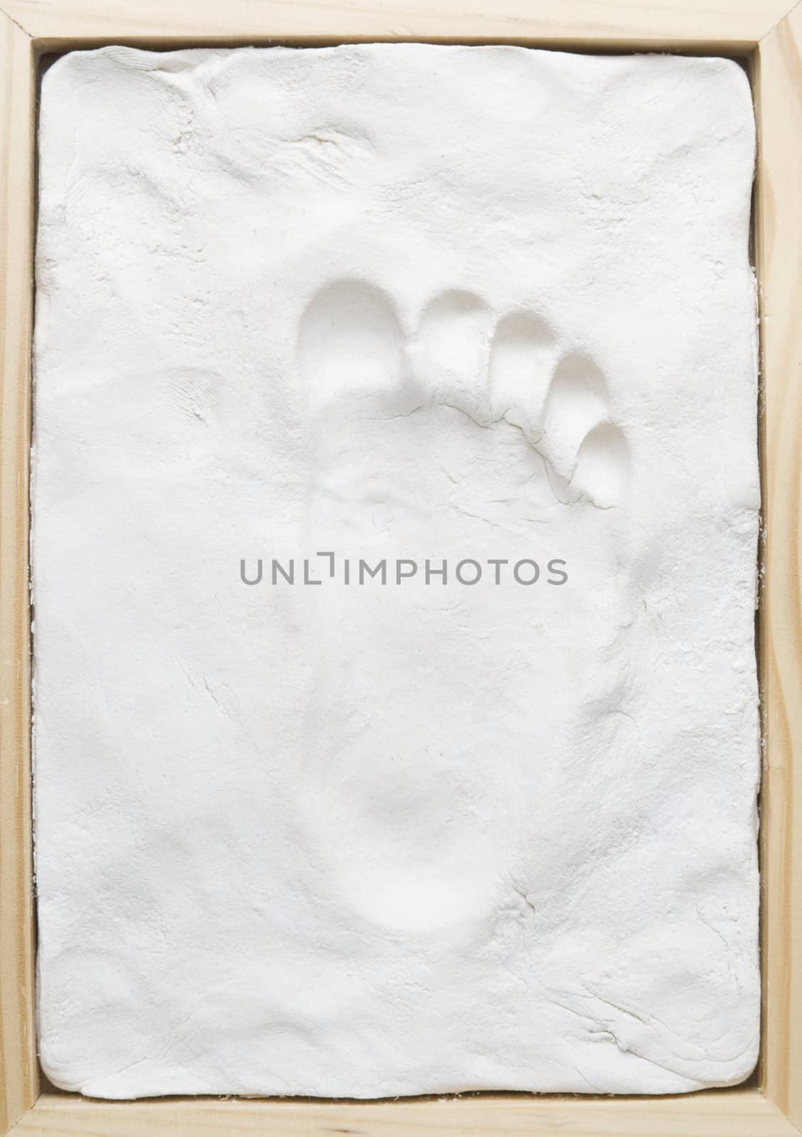 Small child memory footprint on clay in wooden frame