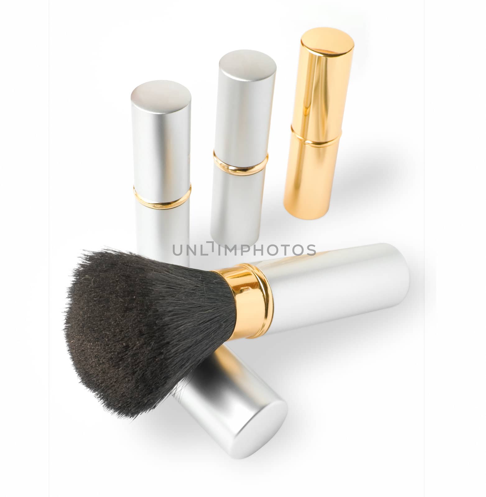 Golden and silver cosmetics set of brush and lipsticks.
