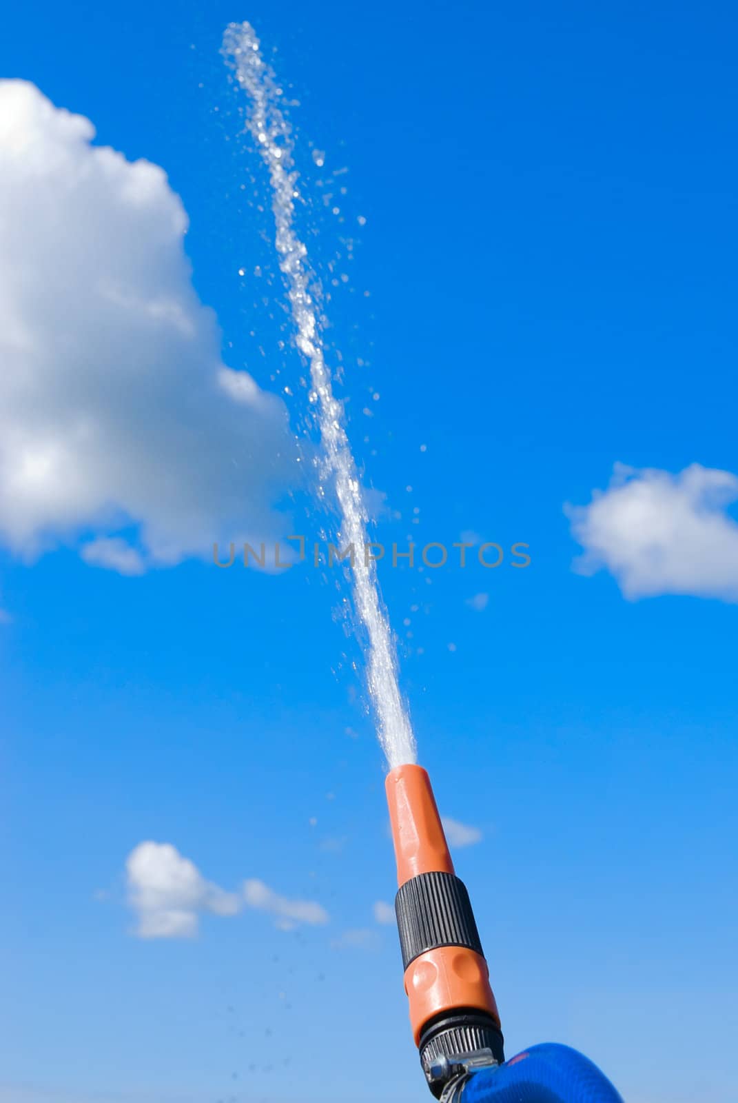 Hose with stream of water flowing in the sky
