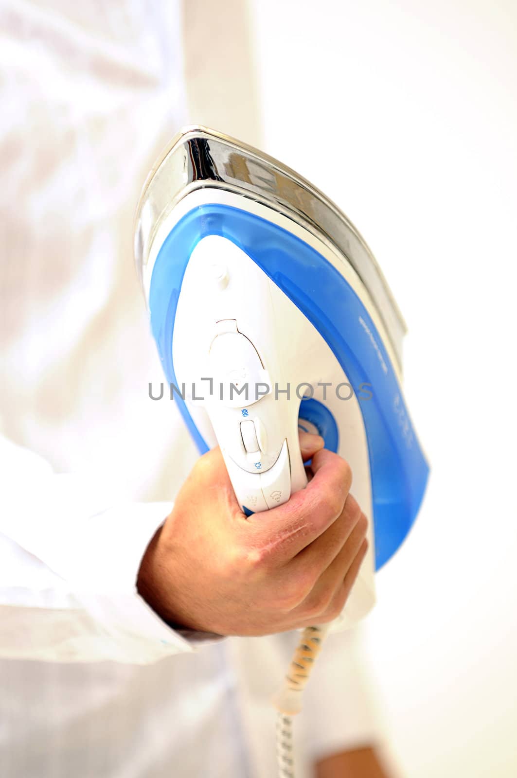 man holding a blue and white clothing iron upside down