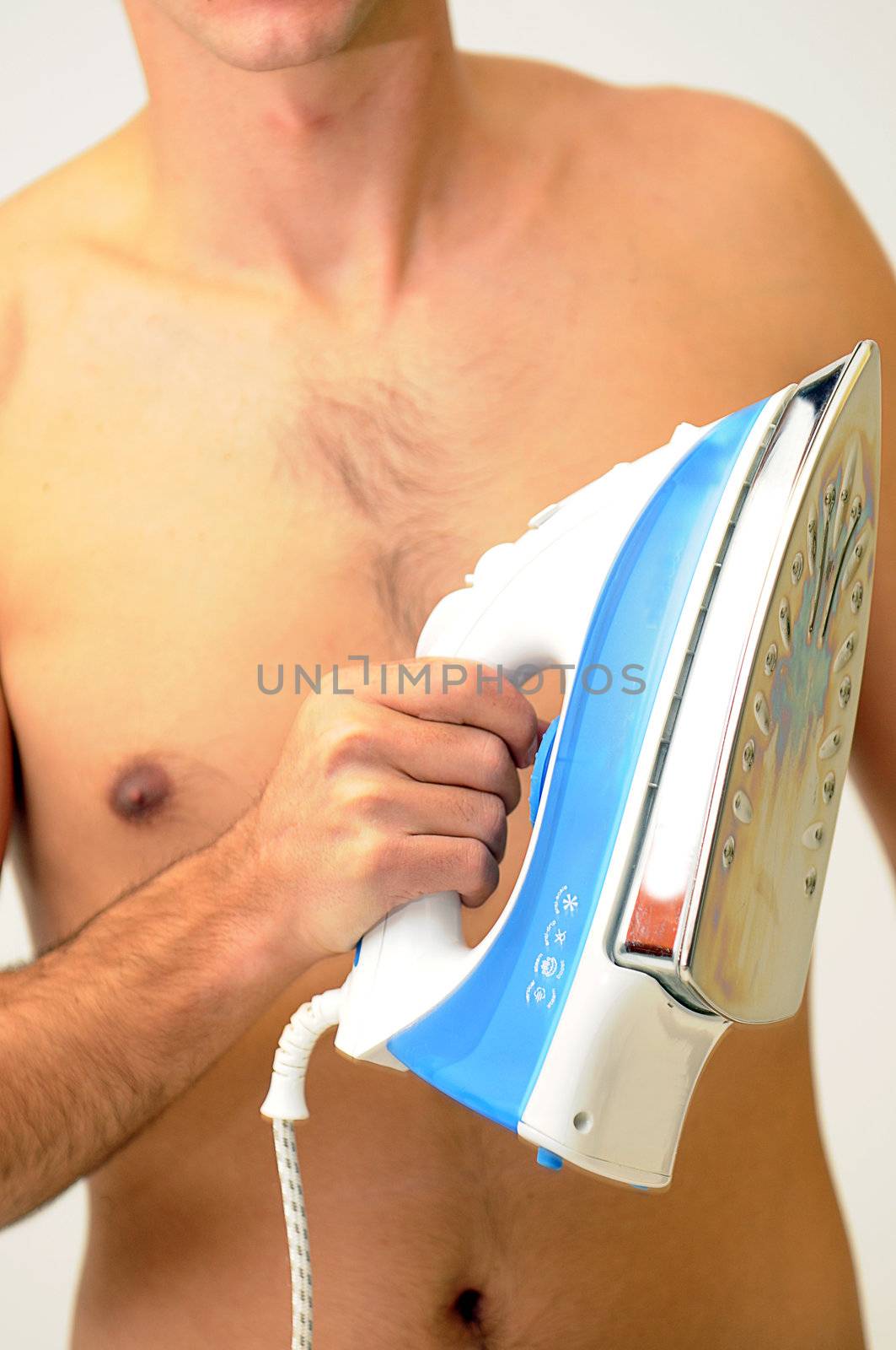 naked man holding a blue and white clothing iron in front of hairy chest