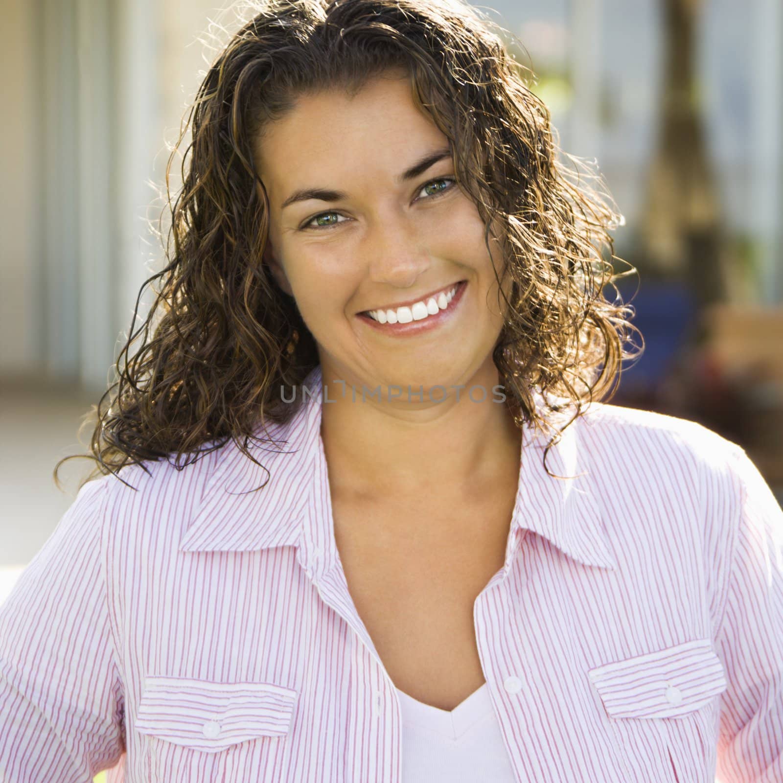 Portrait of pretty young adult Caucasian brunette woman smiling and looking at viewer.