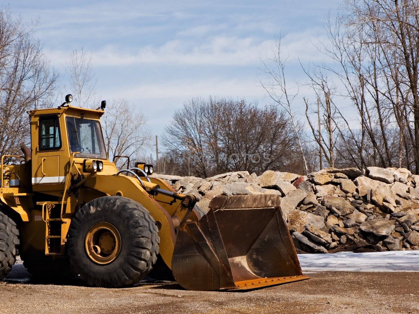 Front loader near a pile of large stones