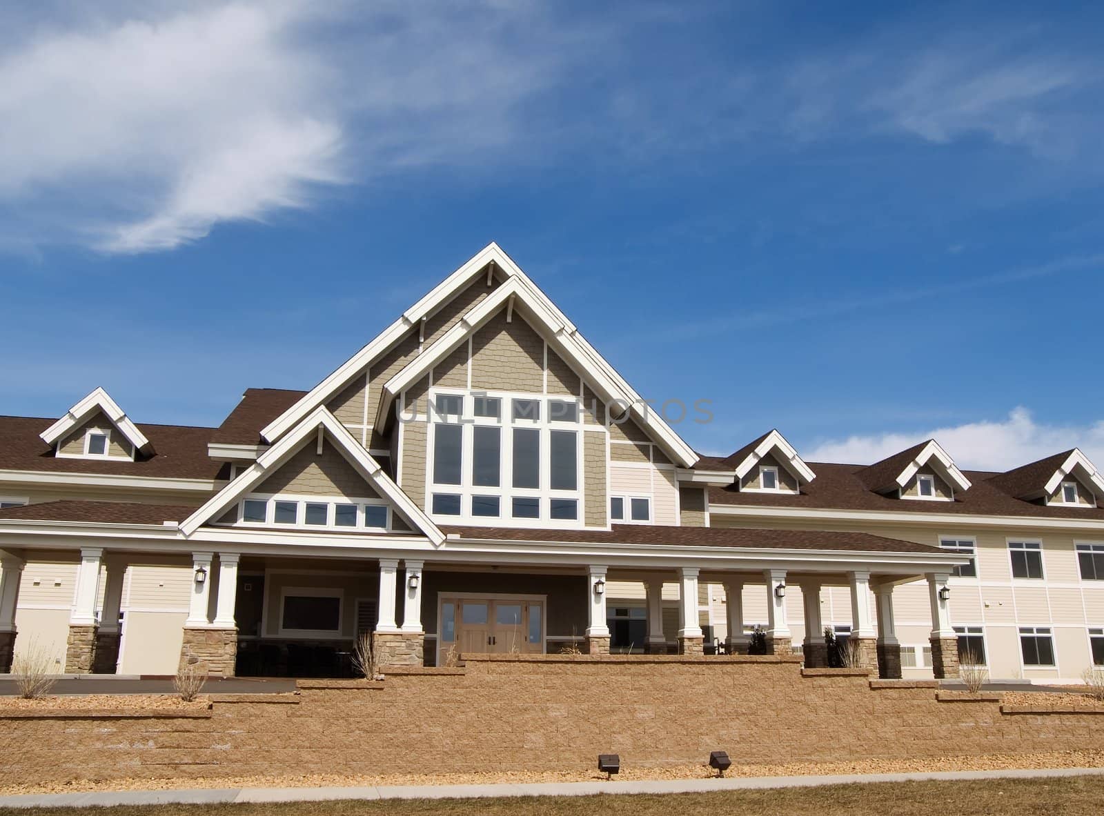 Large sprawling mansion with cloudy blue sky