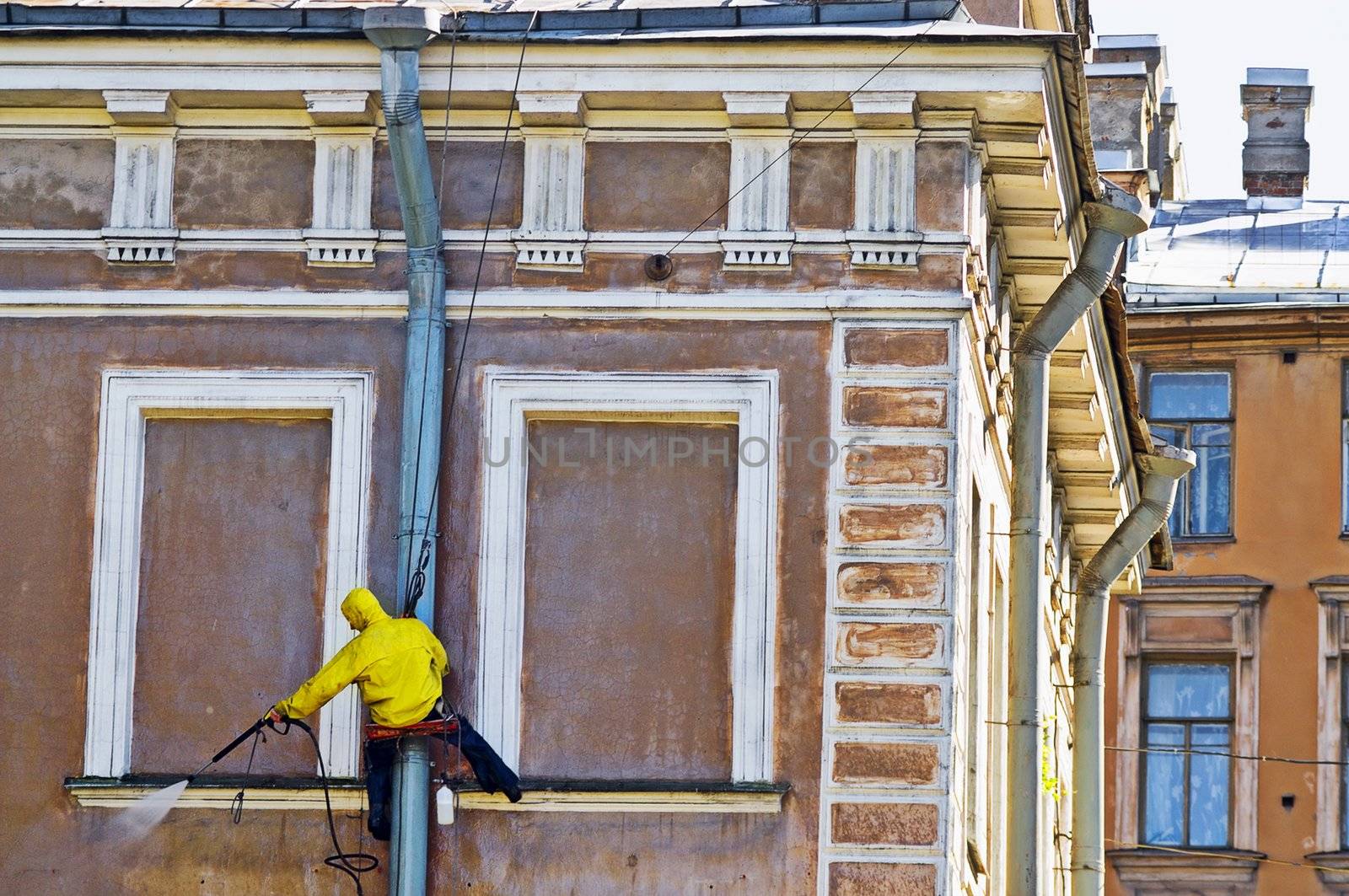 Cleaning service worker washing old building facade