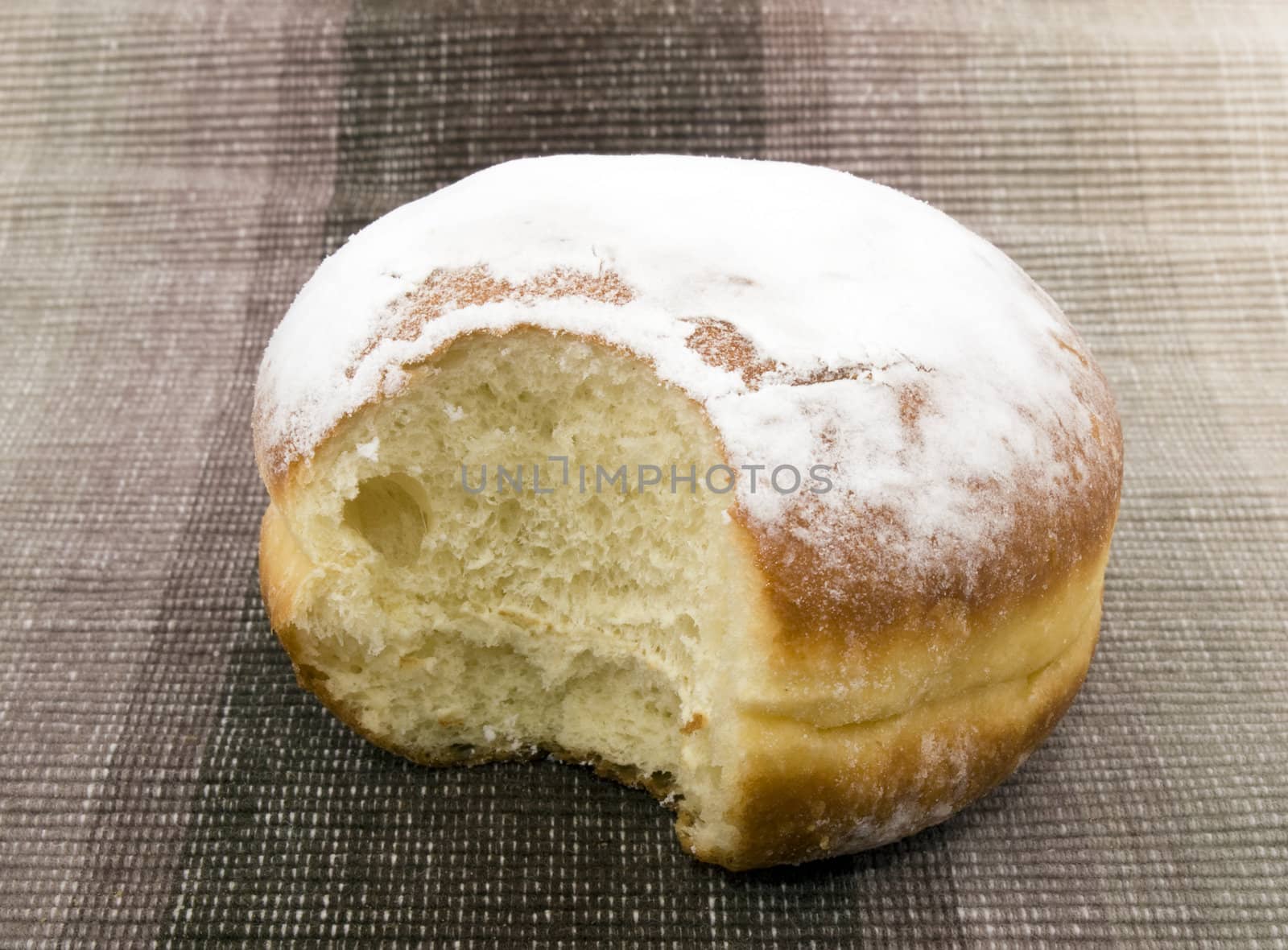 Tasty doughnut on brown fabric background