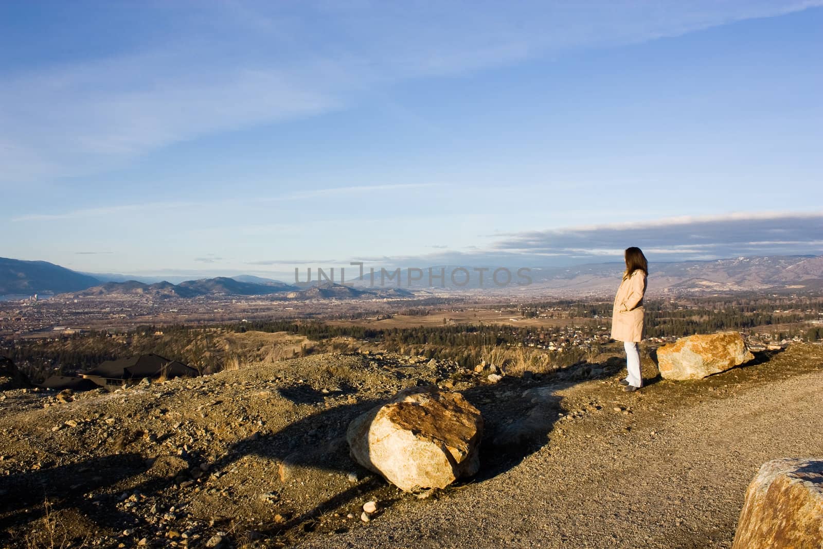 photo of a girl watching horizon from the mountain in a sunny summer day
