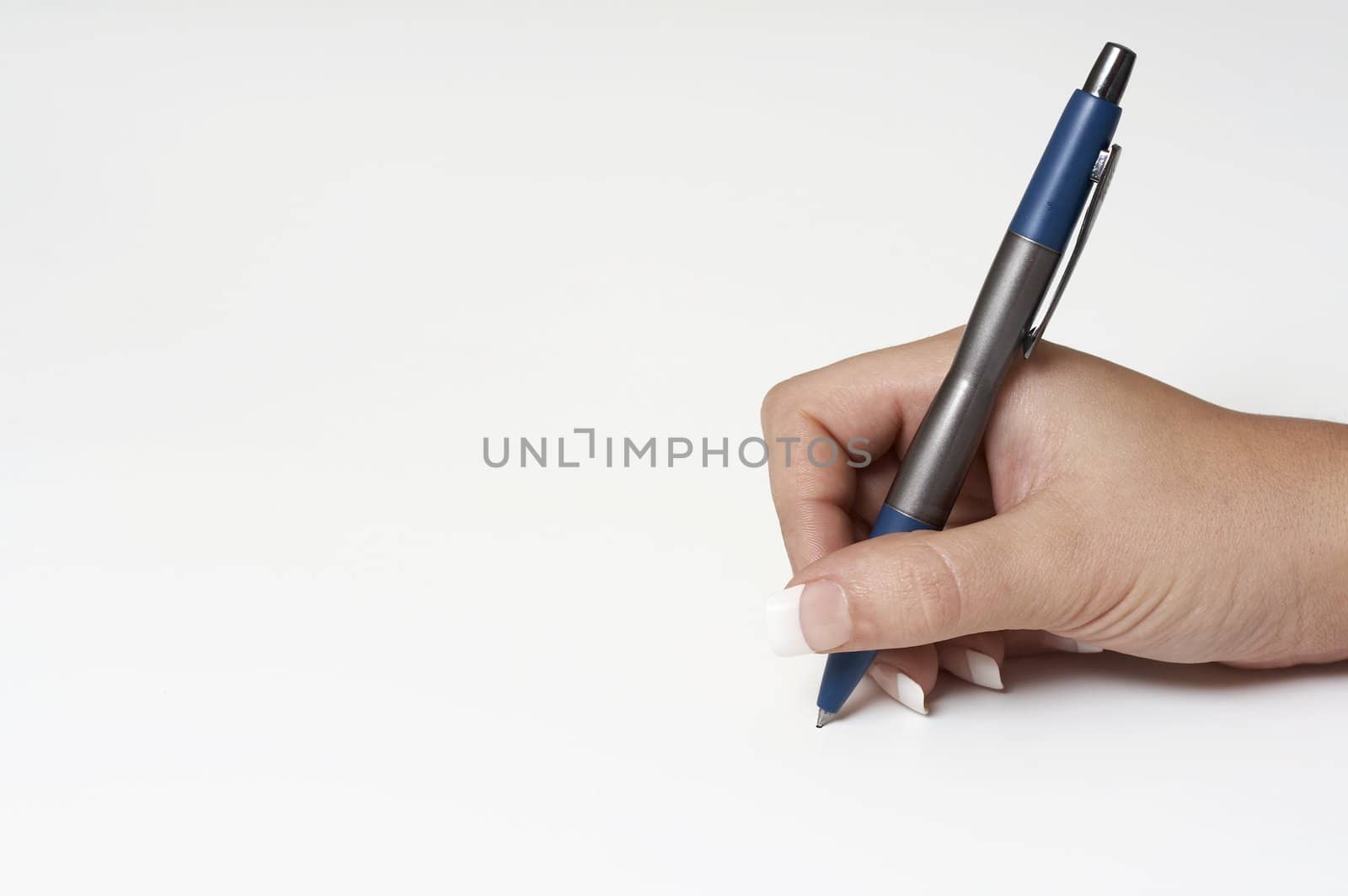 a macro picture of a female hand holding a pen