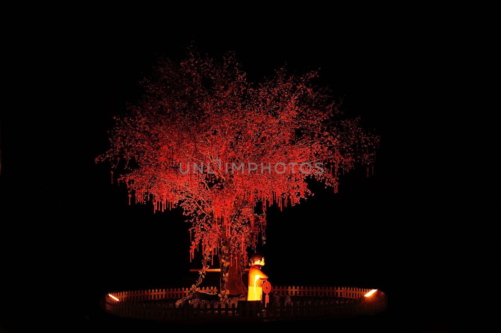 red chinese new year tree with small statue illuminated with red light