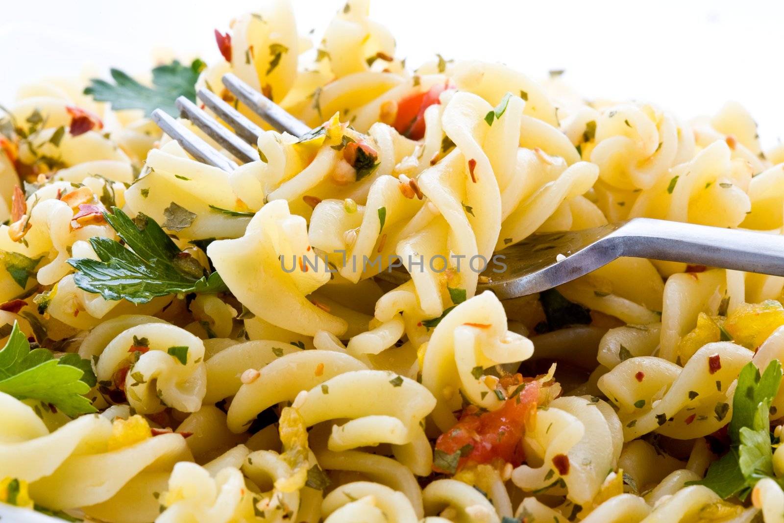 Macaroni with greens on a plate with a fork 
