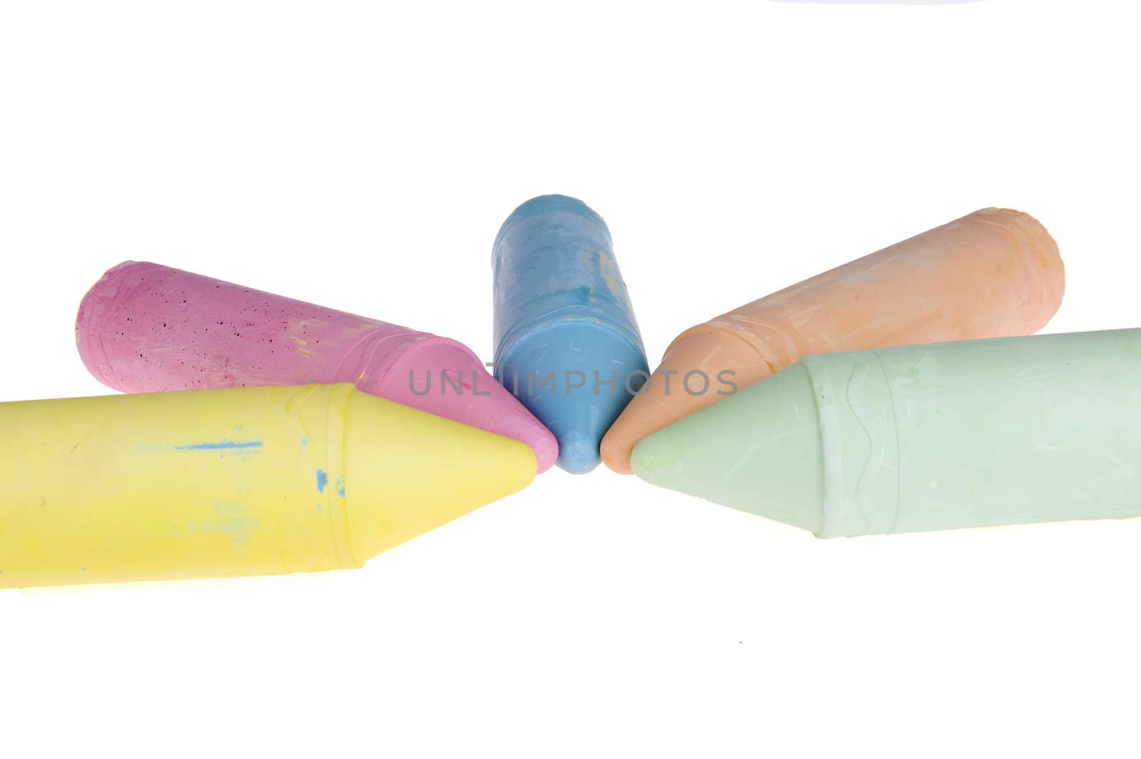 five colorful chalks on a white background