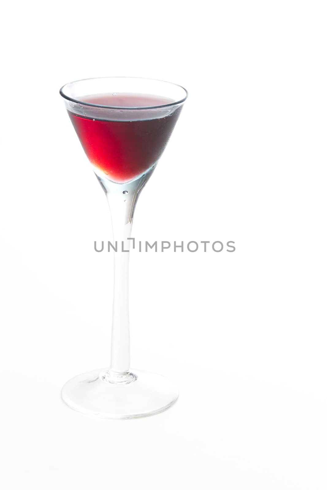 Small glass of red wine against a white background