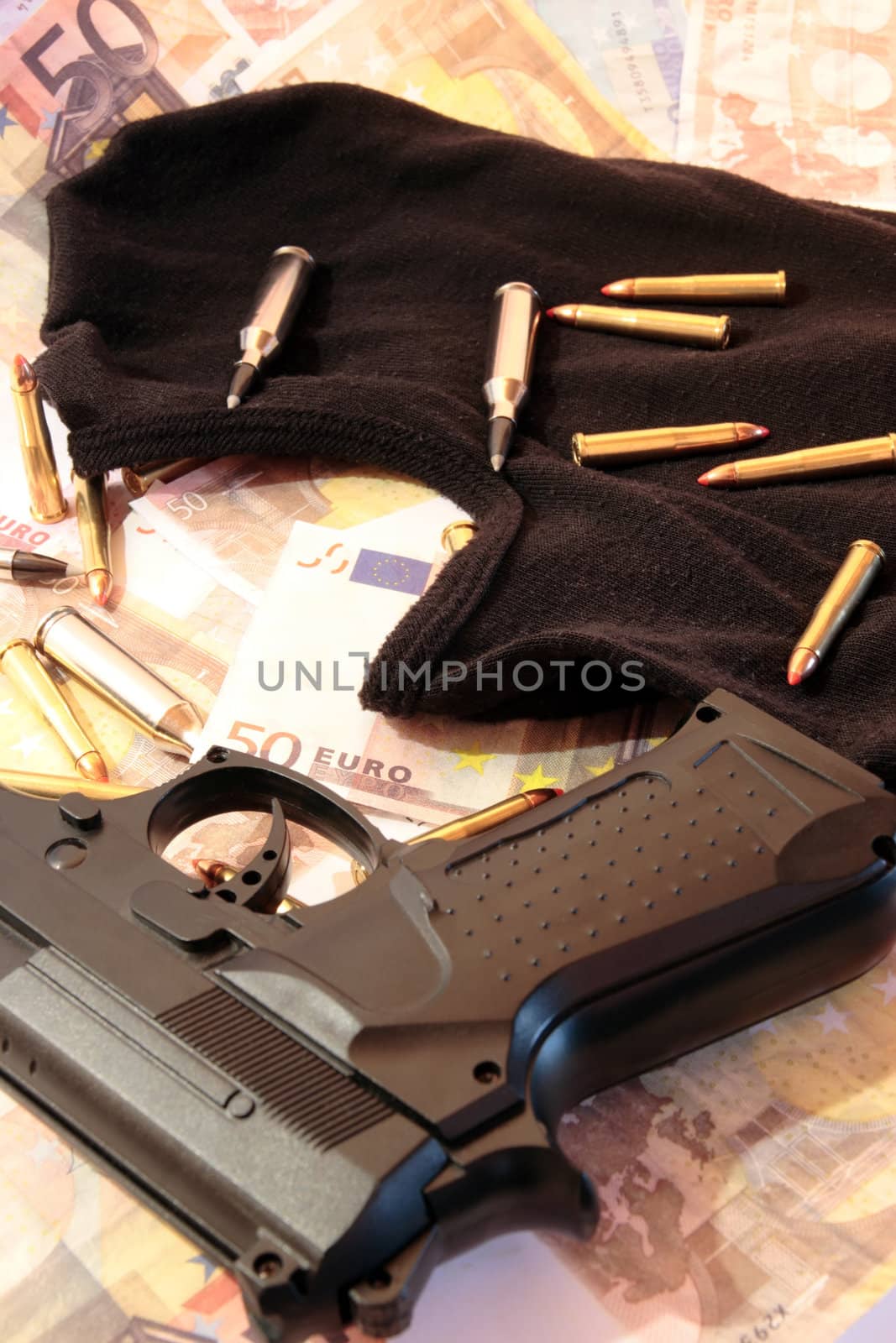 balaclava, money, gun and bullets showing concept of a robber or terrorist activity