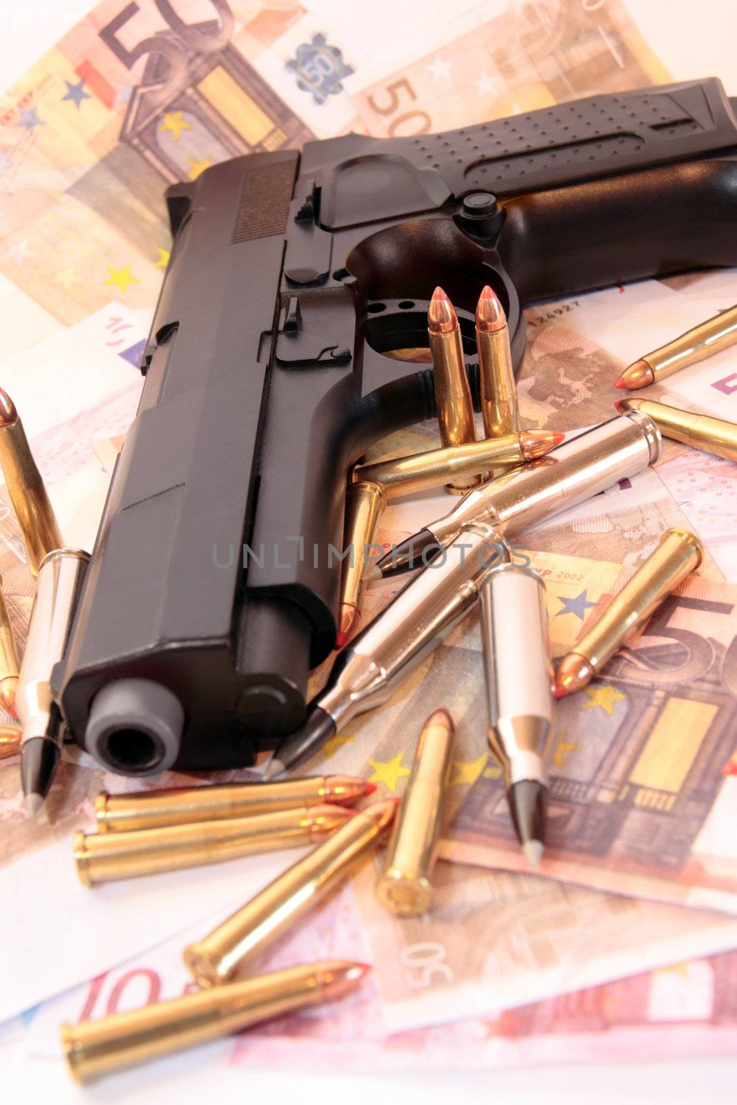 bullets, gun and money showing a dangerous side to life against a dark background