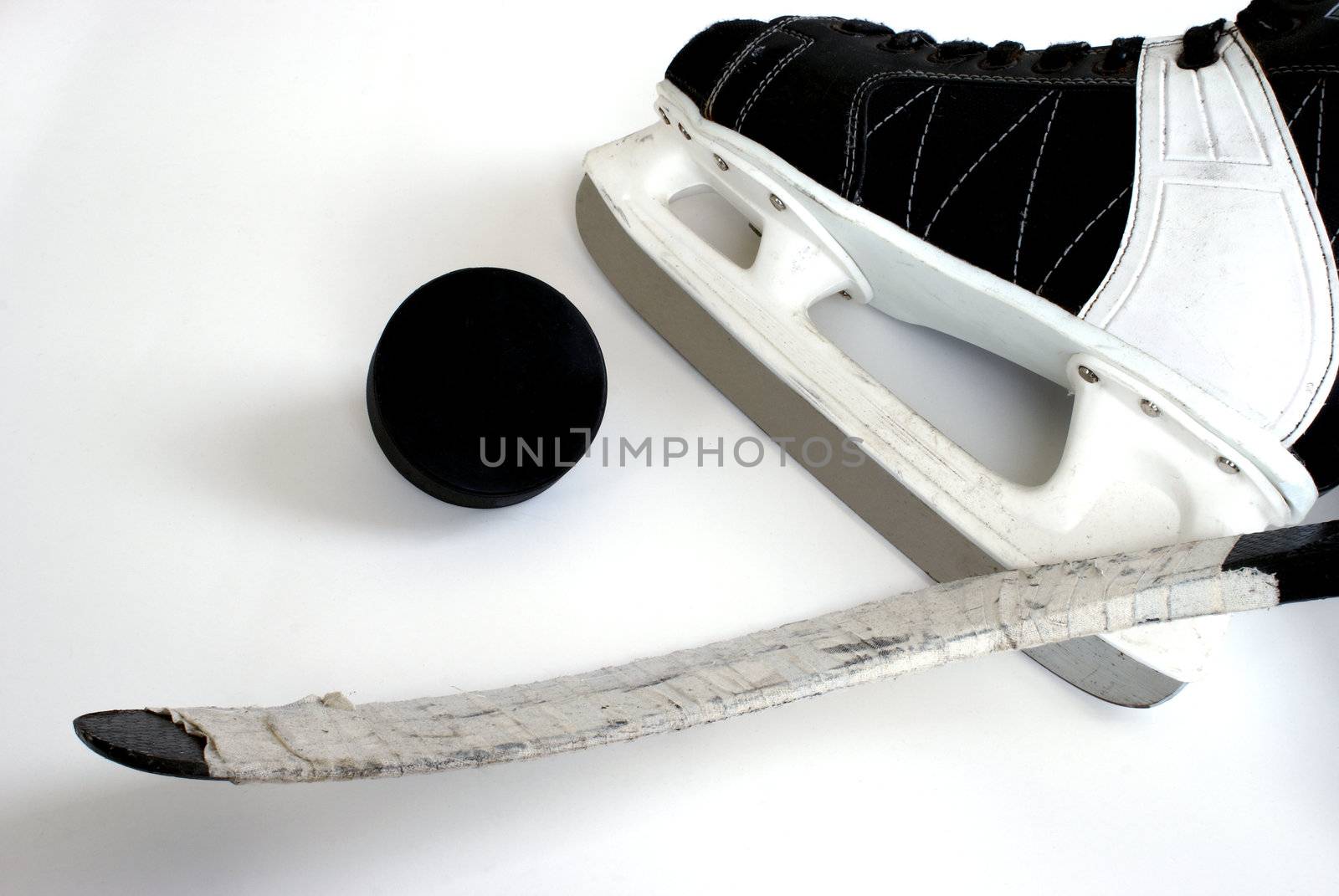 A hockey skate, puck and stick.