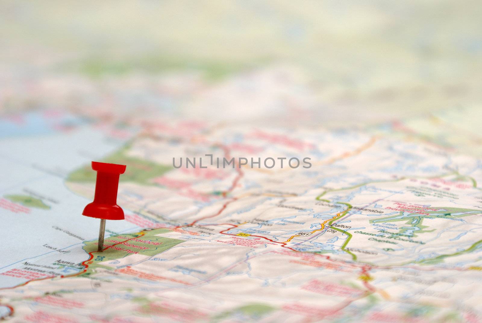 A push pin is inserted on a travel destination of a map.