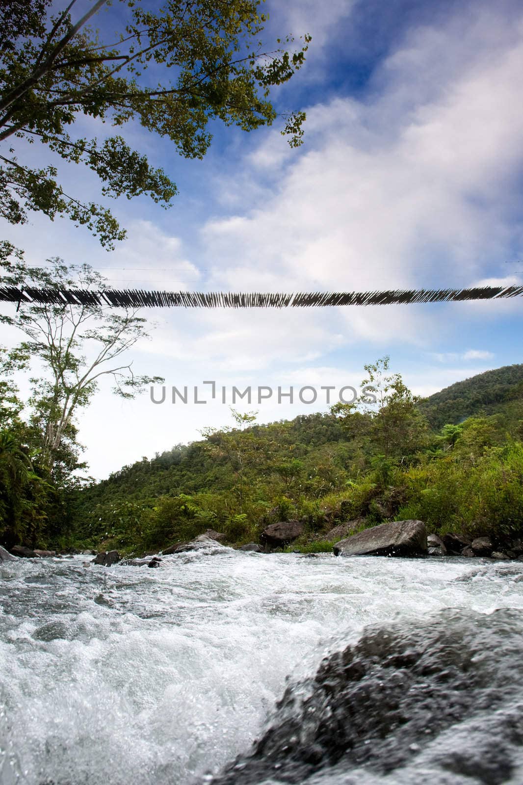 A hanging bridge over a rapid flowing stream