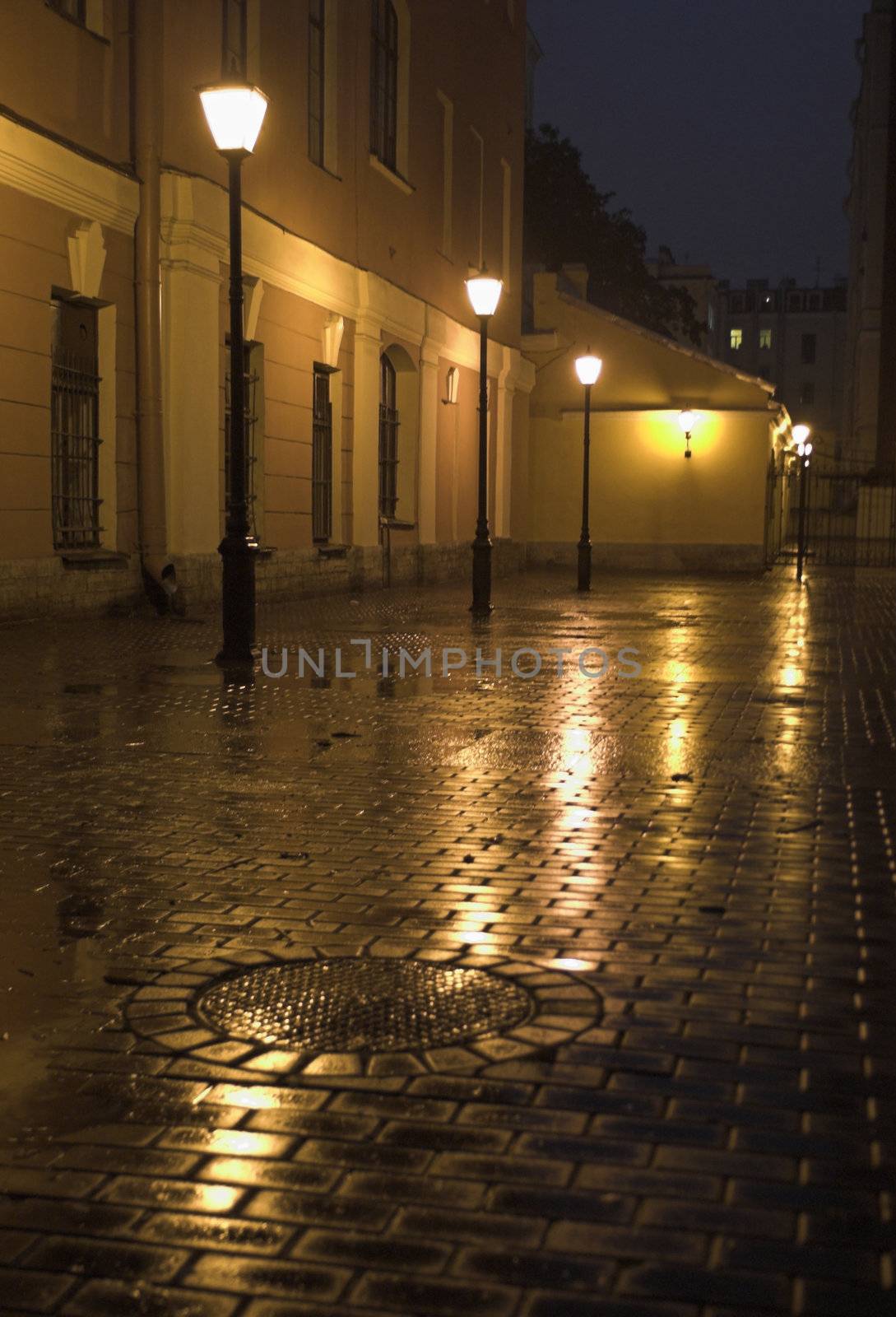 A back yard with street lamps and stone pavement in Saint Petersburg, Russia, at evening.
